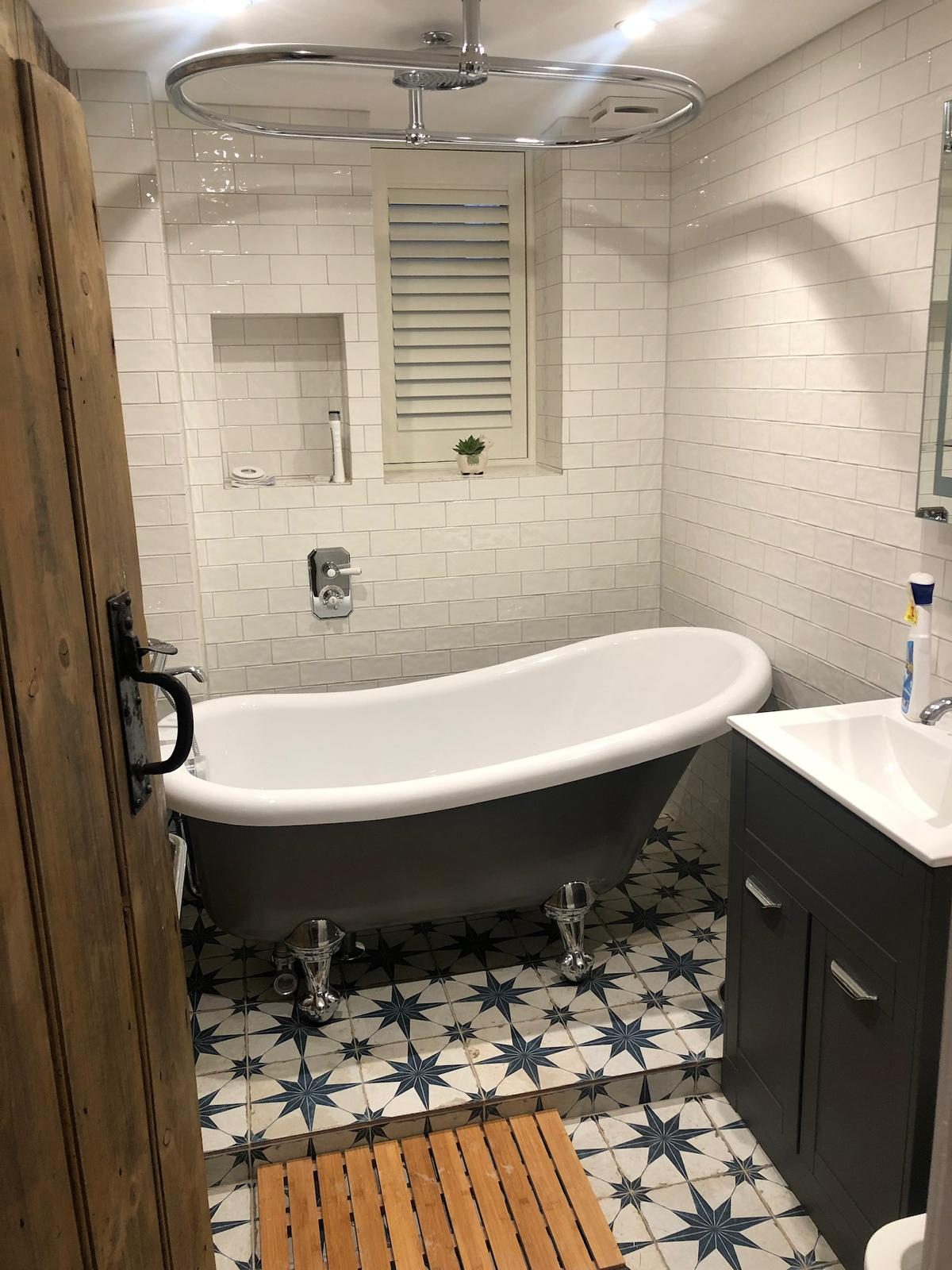 Family bathroom with claw-foot bath, dark vanity and star-pattern floor