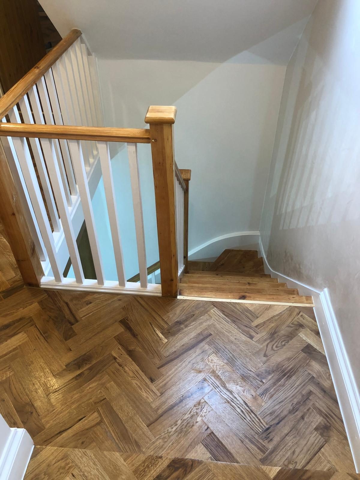 Stair landing with herringbone parquet and painted balustrade